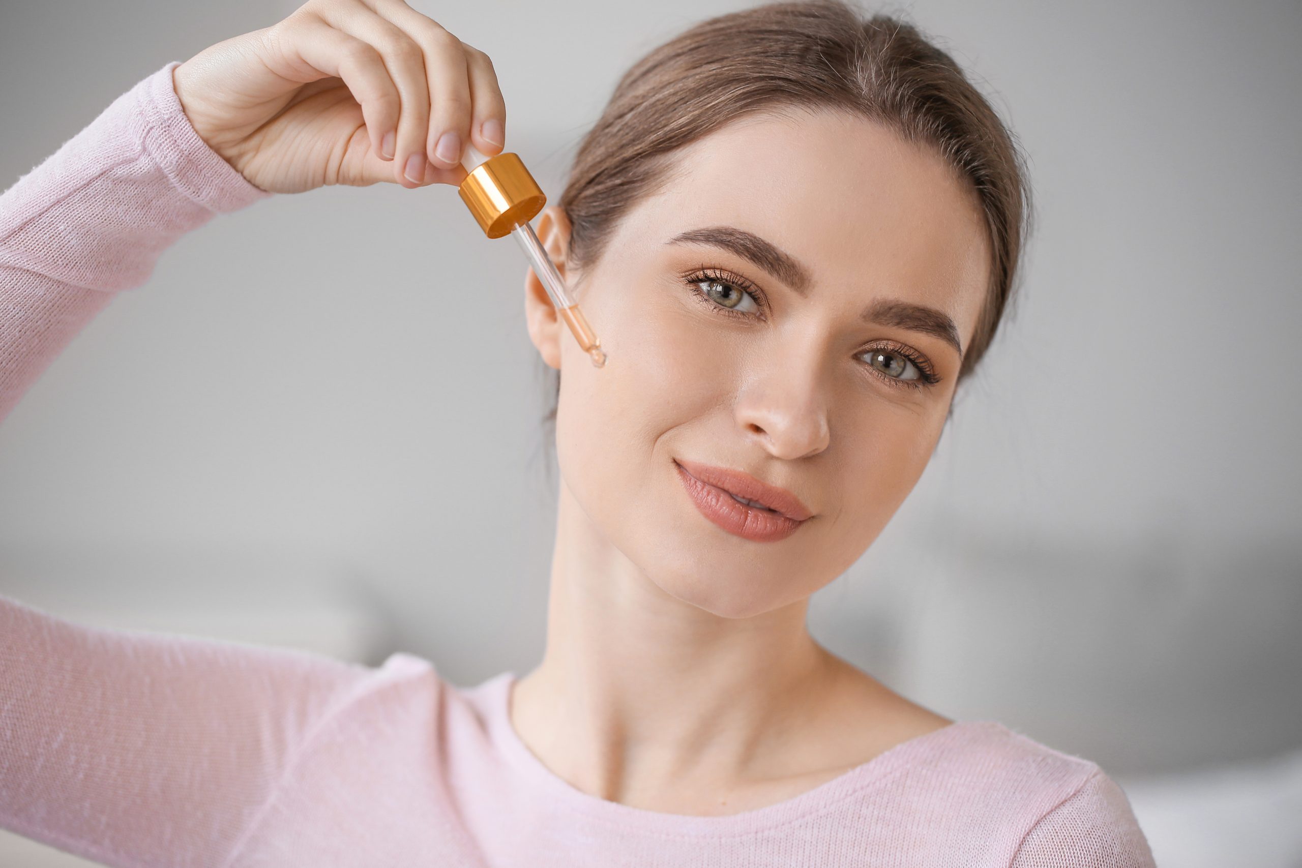 A girl with a cute face which is cumin face using a serum