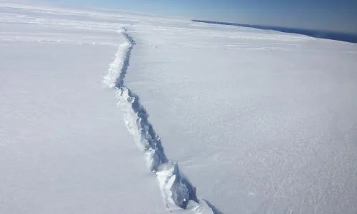 Aerial image of a large crack in the Antarctic ice shelf, suggesting imminent ice shelf collapse.